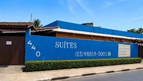 Brick hotel exterior featuring wall-mounted air conditioning units and exposed white PVC plumbing against a sunny blue sky.