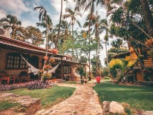 Tropical garden pathway with brick bungalows, palm trees, and hammocks.