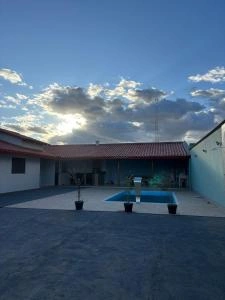 Outdoor pool area with sunset sky, tiled patio, and red roof buildings.