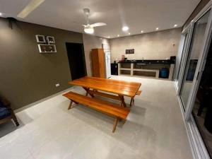 Modern dining area with wooden table, benches, and kitchen.